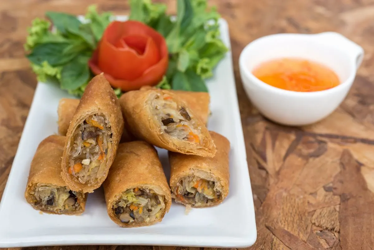 A platter of golden-brown steak and cheese egg rolls