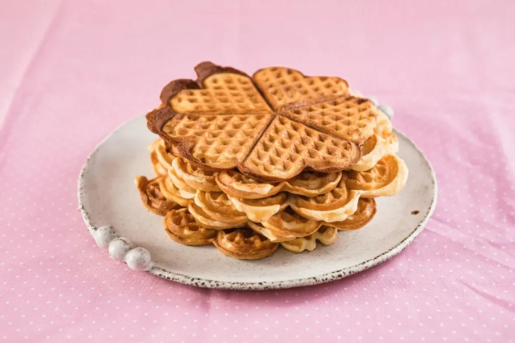 Golden-brown waffle cookies stacked on a plate