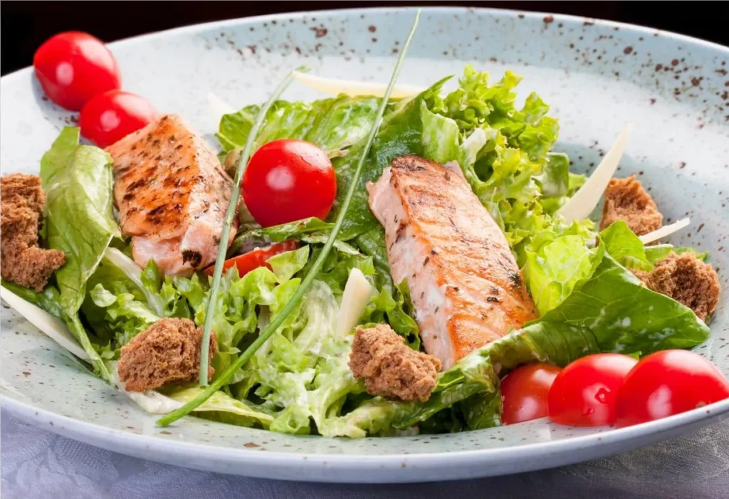 Completed salmon caesar salad in a large bowl